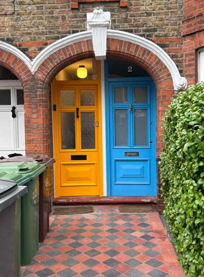 colorful entrance doors with yellow and blue doors surrounded by brick archways and green hedges four vibrant contrasts in entryway